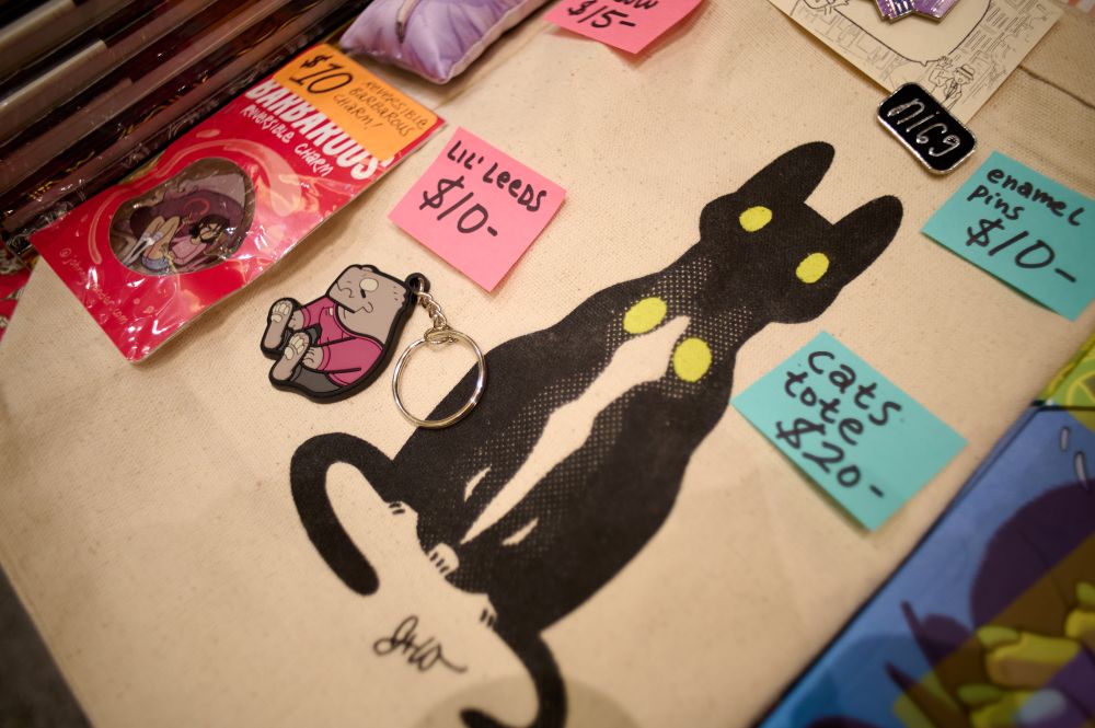 A keychain of Leeds and a tote bag with two black cats. The Leeds keychain is $10 while the tote is $20. Dang, I shoulda gotten a tote!