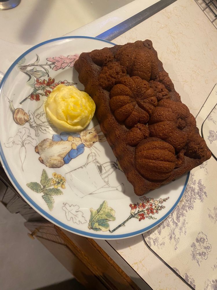 Fall harvest shaped pumpkin bread on a Peter Rabbit dish with butter shaped like a rose 