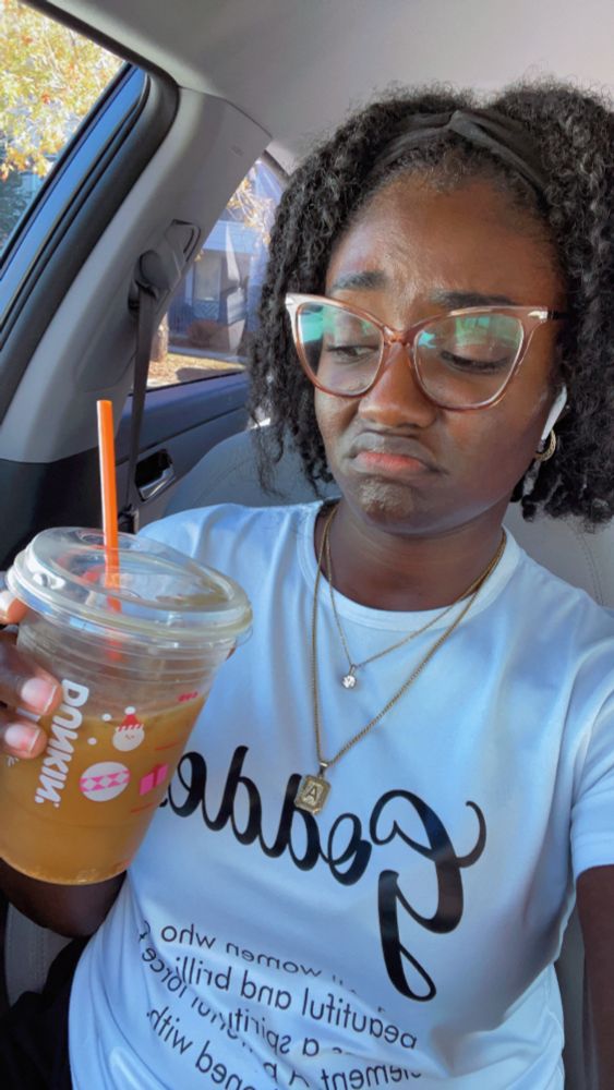 Woman looking at a cup of coffee with a displeased face 