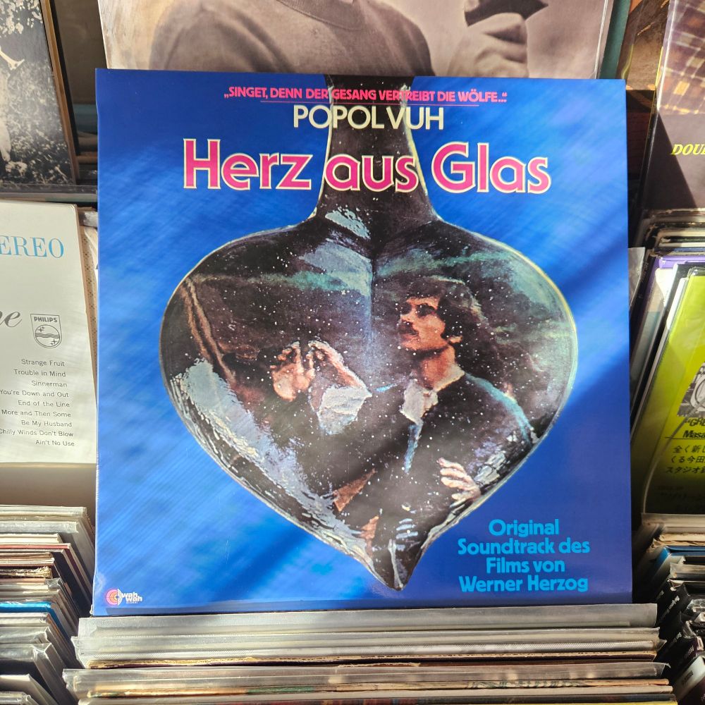 Alternate album cover features a still photograph from the film inside a heart-shaped glass object.