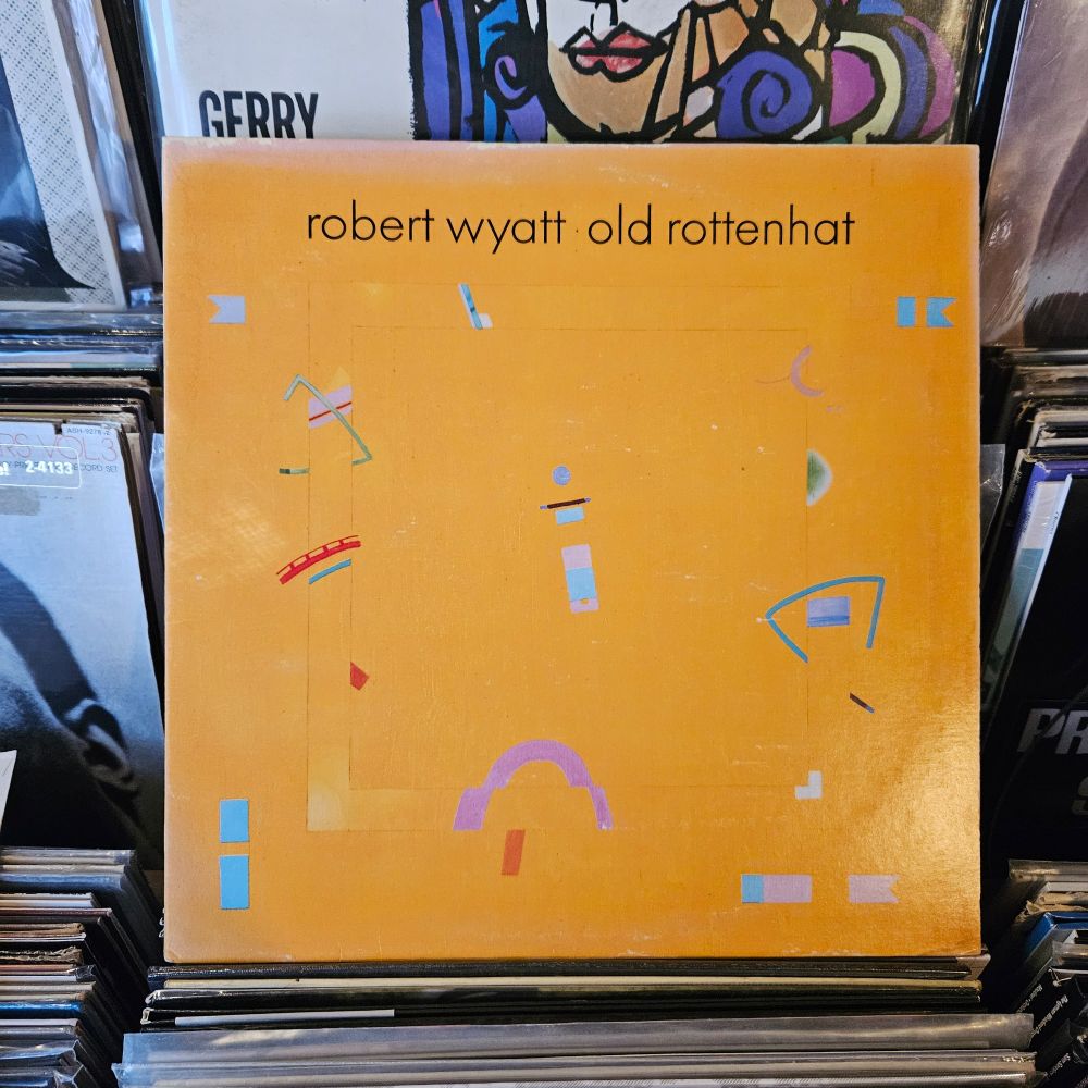 Yellow album cover features some small, colorful, abstract designs. Kind of an 80s minimal vibe.