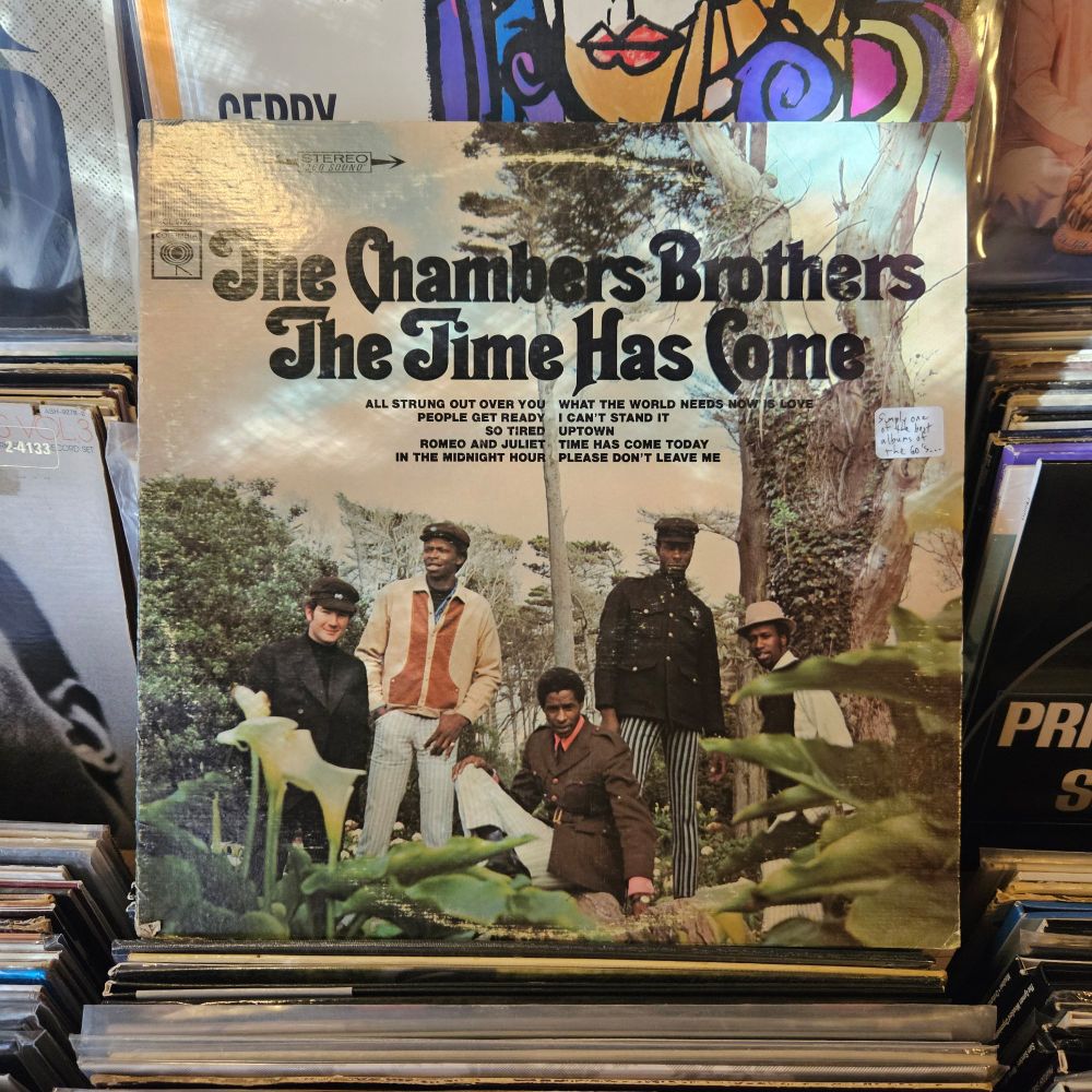 Album cover features a color photograph of the band, standing together in a green, wooded area.