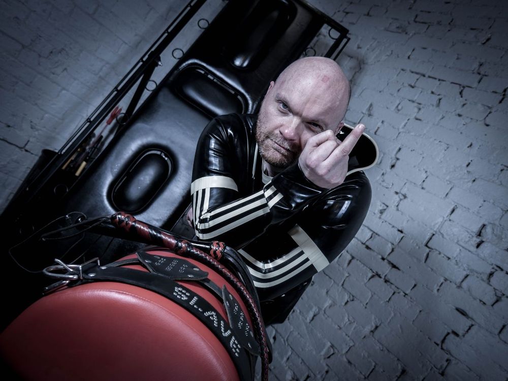 Me dressed in latex with a finger up in the air to Xitter.