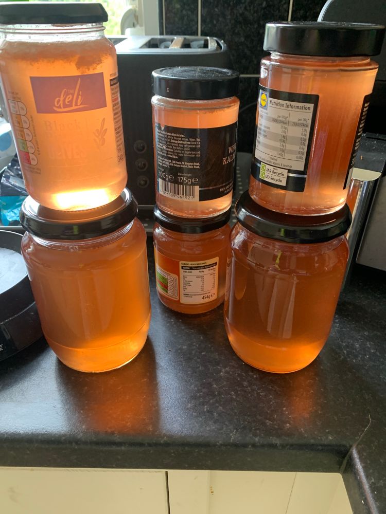 Six jars of crab apple jelly in mismatched jam jars.