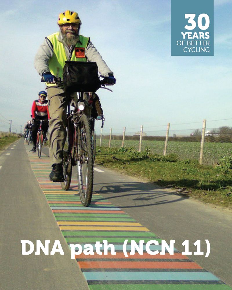 Campaigner Jim Chisholm wearing a yellow cycle helmet rides along the stripes of the DNA path from Great Shelford. More cyclists can be seen behind him.