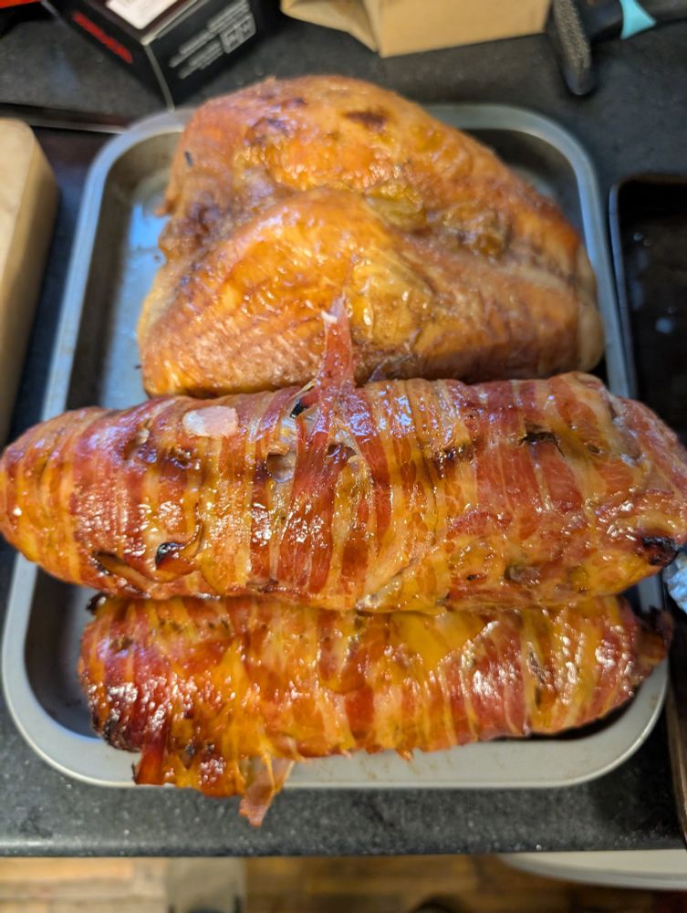 Cooked bacon, deboned turkey legs and stuffing wrapped as sausages and turkey crown