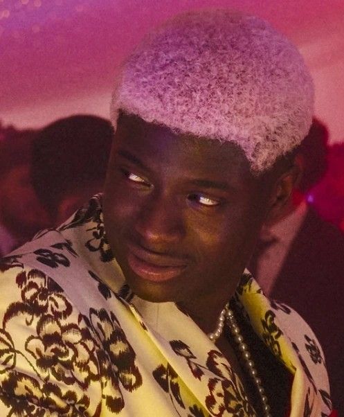 A Black man with short pink hair 