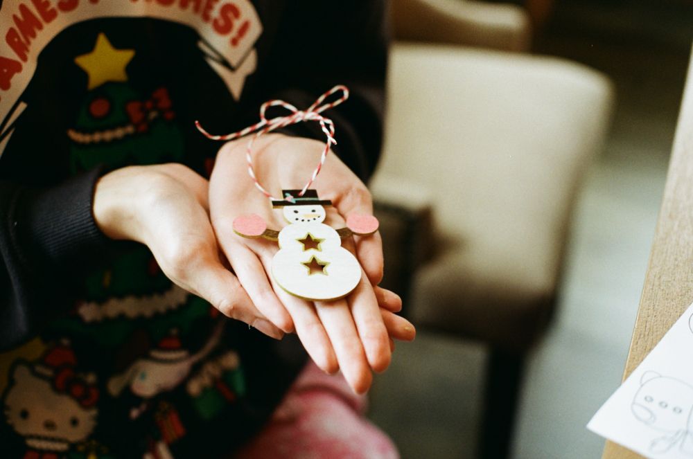 stas' hands showing off a painted wooden snowman craft 

#canon #ae-1 #kodak #gold200 #35mm 📷