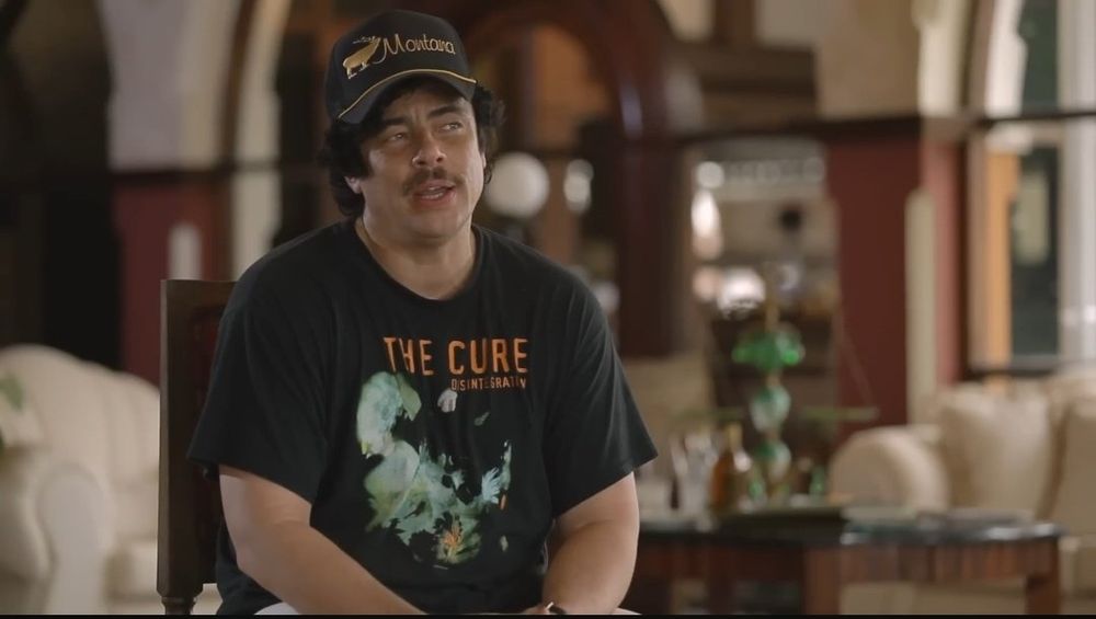 benicio wearing a montana hat and the cure disintegration tee