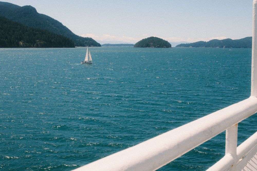 on bc ferry shot thru boat railings, open water with sailboat on upper horizon

#x100vi #fuji #classiccubanneg #photography 📷