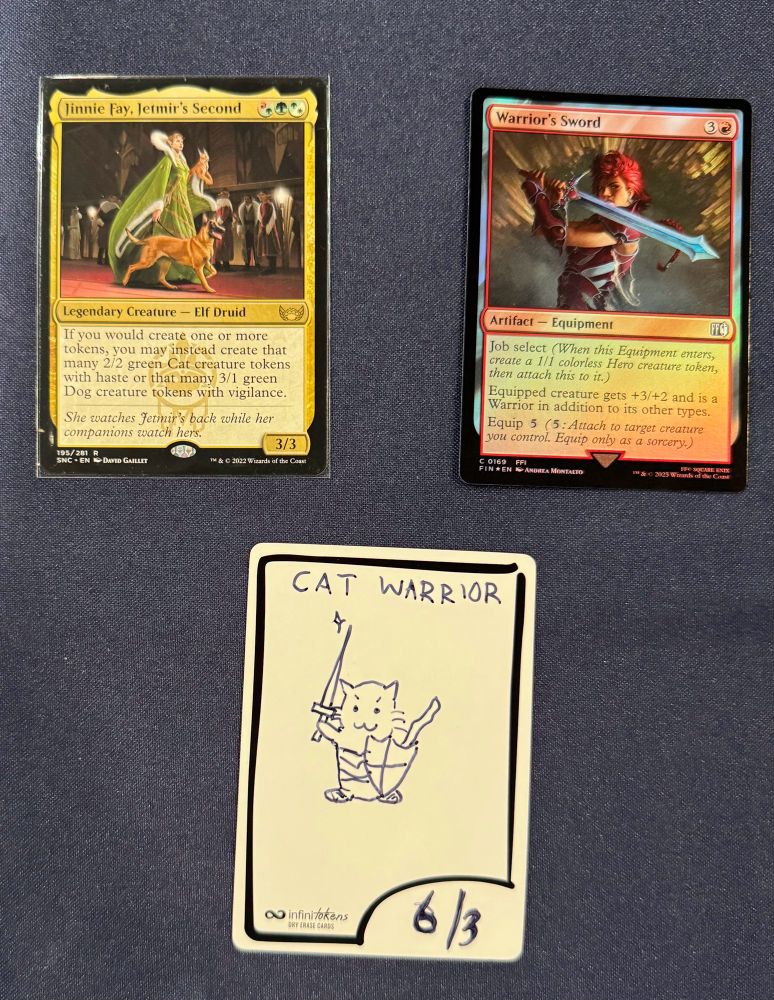 Photo of the MTG cards Jinnie Fay, Jetmir's Second and Warrior's Sword and an Infinitoken. The token is labeled "6/4 Cat Warrior" and depicts a small kitten wielding a sword and shield with a fierce :3 smile.
