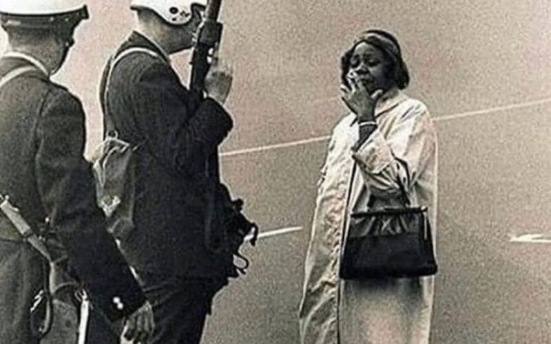 Famous photo of Louise Jenkins (Meriwether) smoking a cigarette as police try to question her at a protest in 1957.