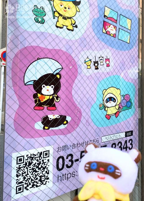 オフィスに掲示されているポスターと、ぽこすけぬいの写真です。ポスターのイラストは、傘をさしたポップ、レインコートを着たポコ助など湯つらしいイラストです。