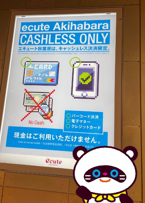 エキュート秋葉原のポスターとポコ助の写真です。ポスターには、キャッシュレス決済限定であり現金を利用できない旨が書かれています。