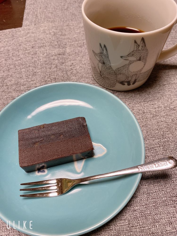 狐の柄のコーヒーカップと水色の皿に乗った羊羹「ノワールの調べ」チョコレート羊羹とオレンジピール羊羹の2層になっている