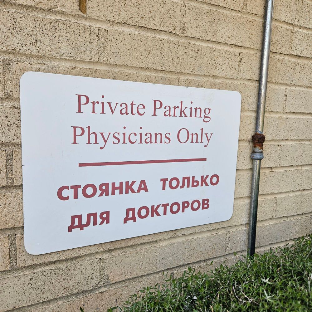 Sign that says "private parking physicians only" in English and Russian