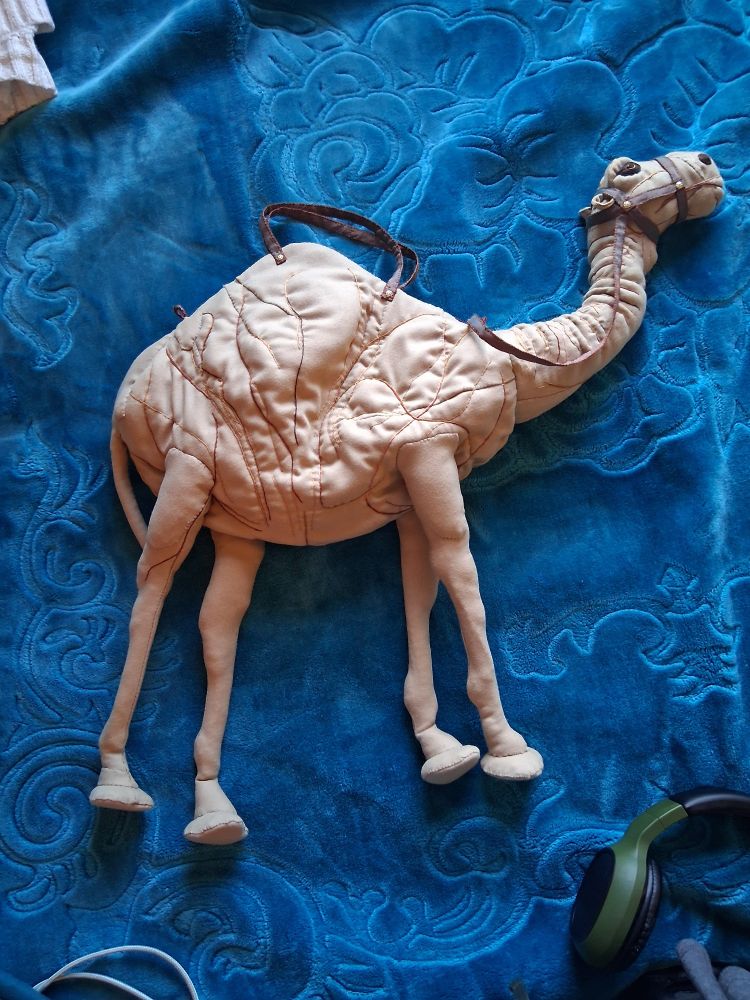 A purse that is a camel. Or a camel that is a purse. A stuffed camel that is not a stuffed camel. That is also a purse. 