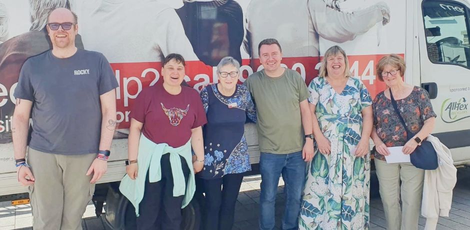 Five people standing together outside an Action Cancer branded van.
