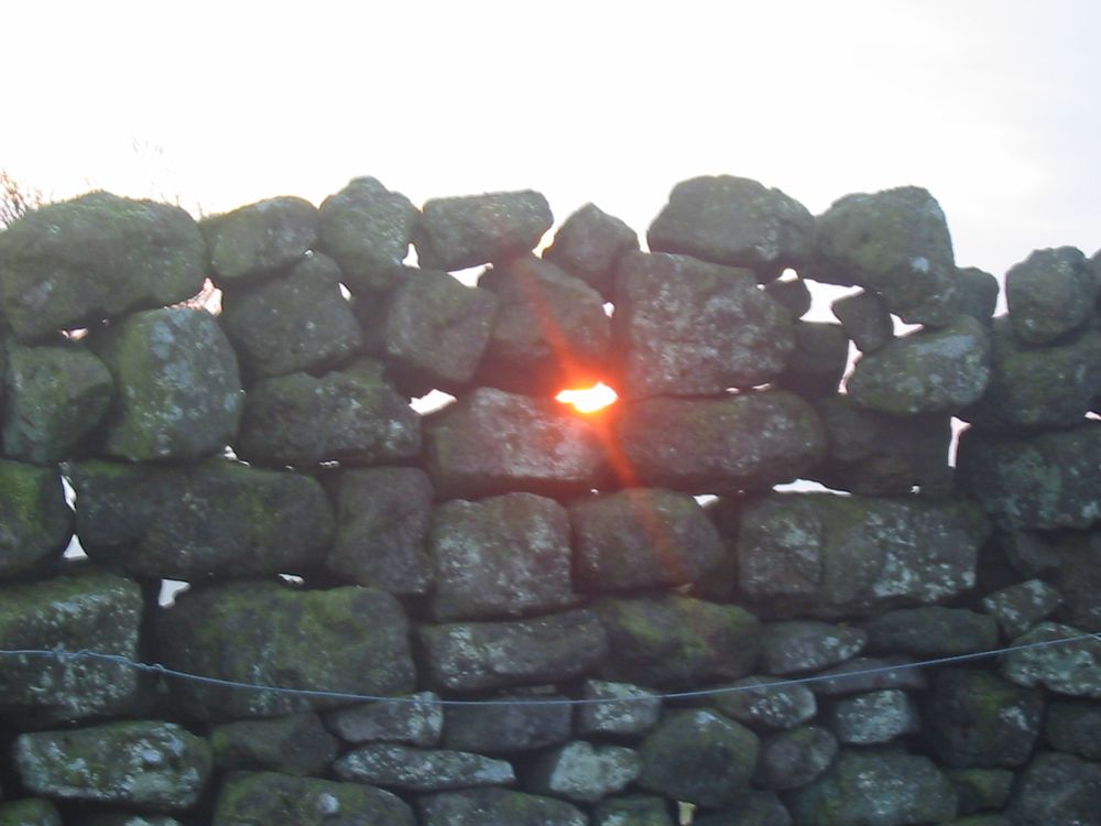 Sun shining through a dry stone wall