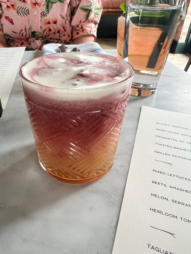 Picture of a lambrusco cocktail on a dinner table 