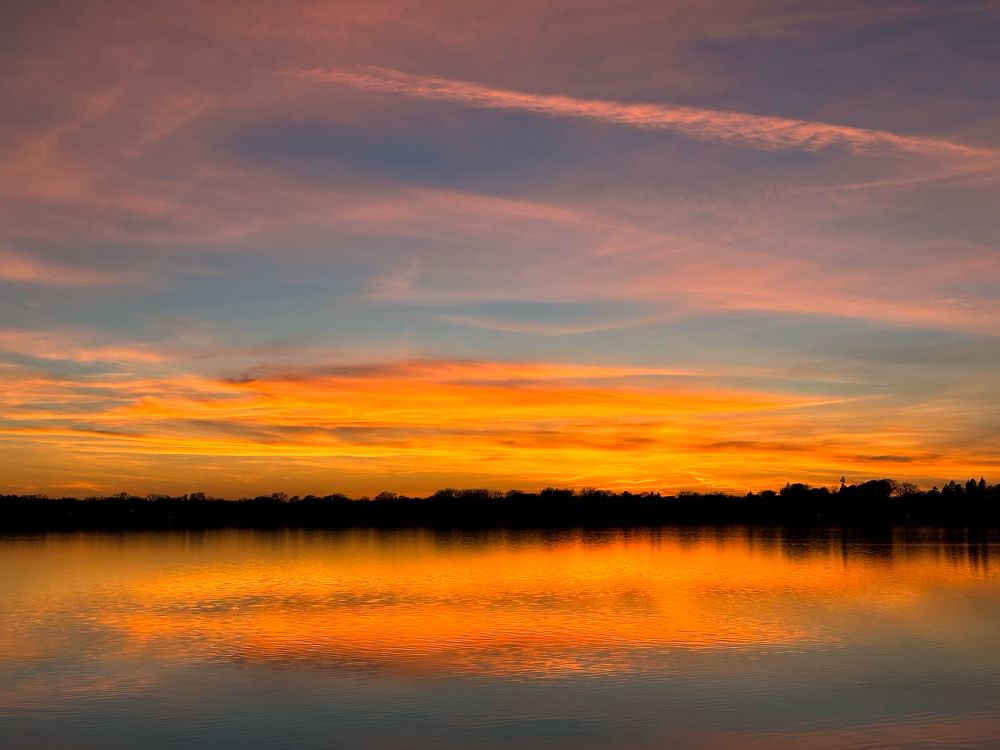 Orange, pink and blue sunset reflected in a calm lake