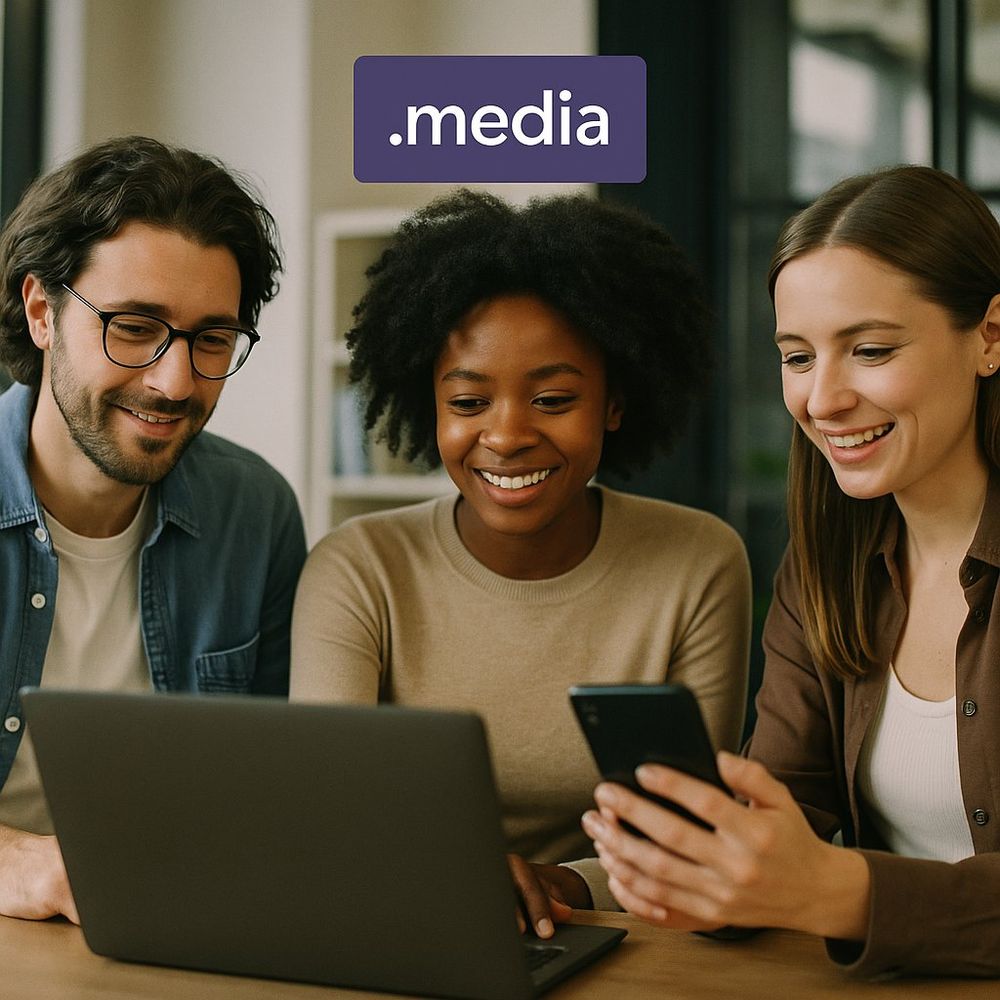 Professionals in an office using technology devices, with a small box at the top indicating '.media' domain name.