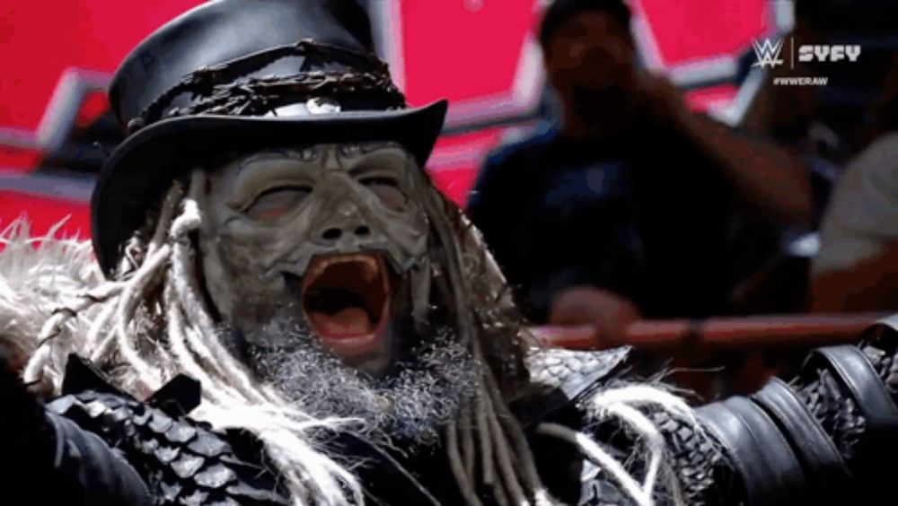 a man with dreadlocks and a mask on his face is screaming in a wrestling ring sponsored by syfy