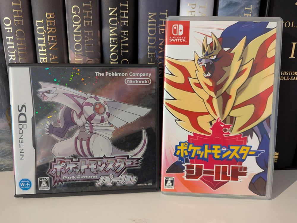 A picture of the video game cases of Pokémon Pearl for the NDS and Pokémon Shield for the NSW. Both games are the Japanese version. 