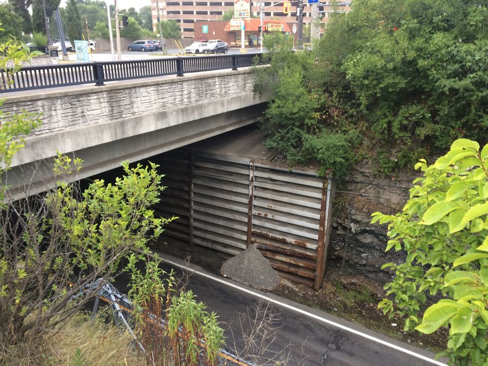 A bridge over Sherman cut with metal retaining wall  cracking open and gravel pouring out