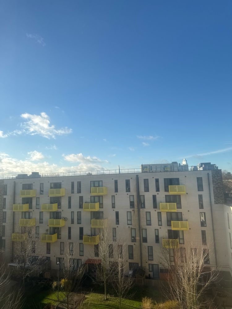 Photo of the view from my bedroom window of the blue and clear sky outside. 