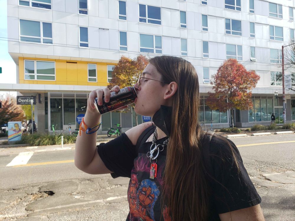 photo of me drinking a monster on the sidewalk 
