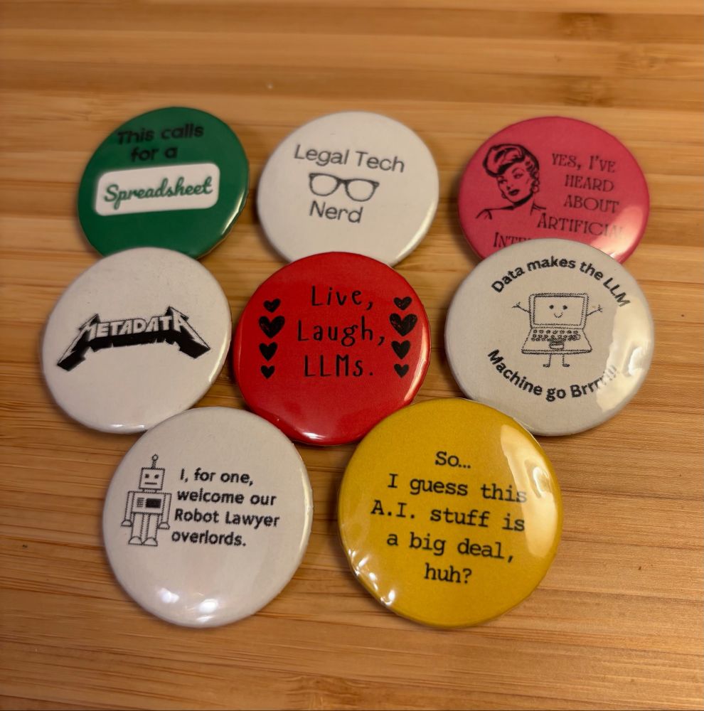 A collection of legal tech themed buttons, like one that says “love laugh LLMs” and another that says Metadata in Metallica font