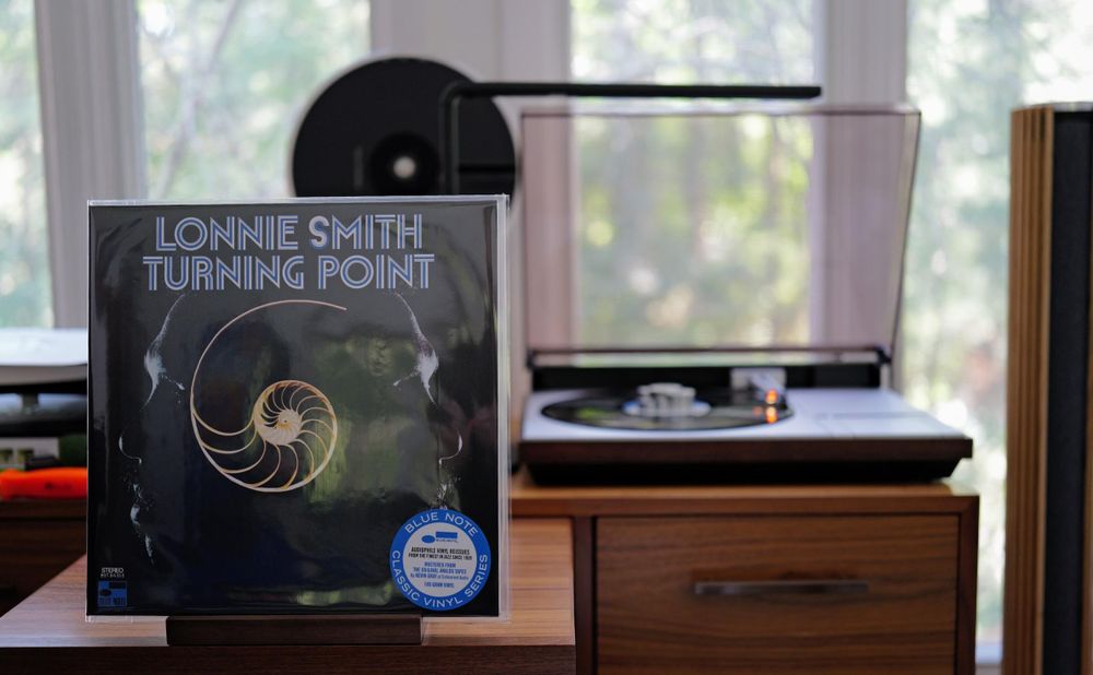 Lonnie Smith - Turning Point LP cover.

On a dark background, what looks to be Lonnie Smith and Lee Morgan (?), with a nautilus in between.

The black LP plays on a vintage, restored Bang & Olufsen Beogram 4000 linear-tracking turntable to the right.