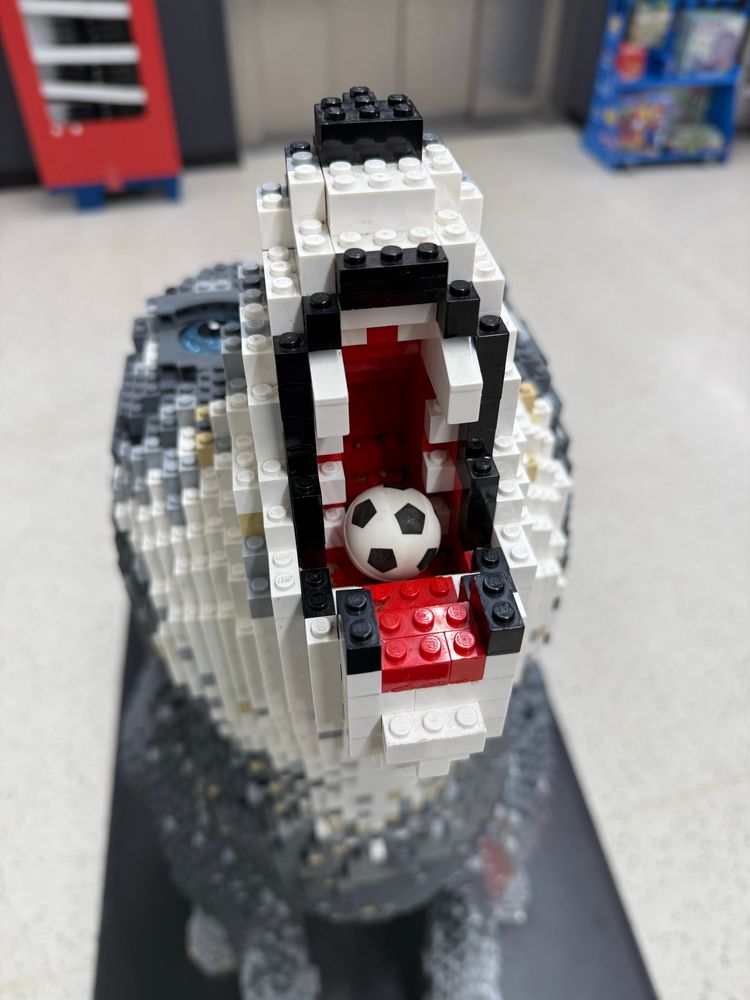 A closeup of the Lego wolf’s muzzle reveals that someone has dropped a tiny football into it