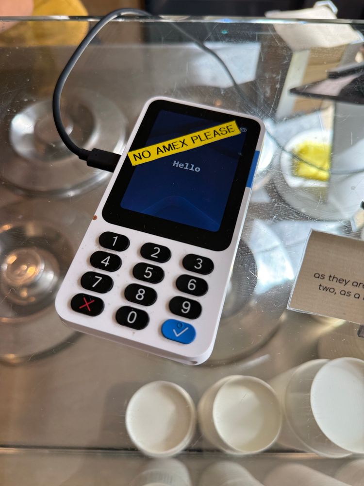 An ice cream shop has an iZettle reader for taking card payments. A yellow label saying “No Amex please” has been stuck across the device’s screen at a 45 degree angle