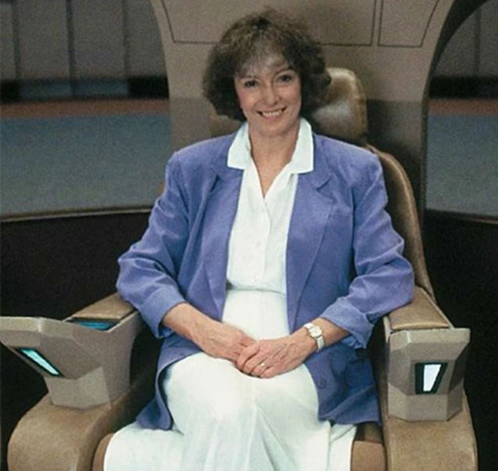 Jeri Taylor, sitting on the bridge of the Enterprise (NCC 1701-D)