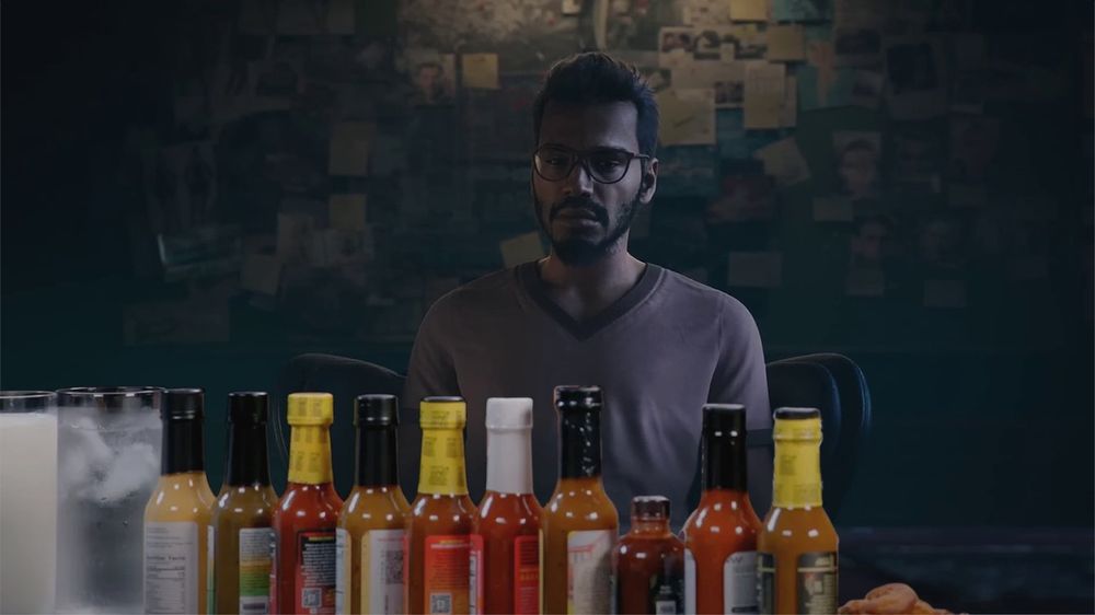 Dr. Harishva Pandey, may his soul rest wherever British people rest, in front of the sauces from Hot Ones.