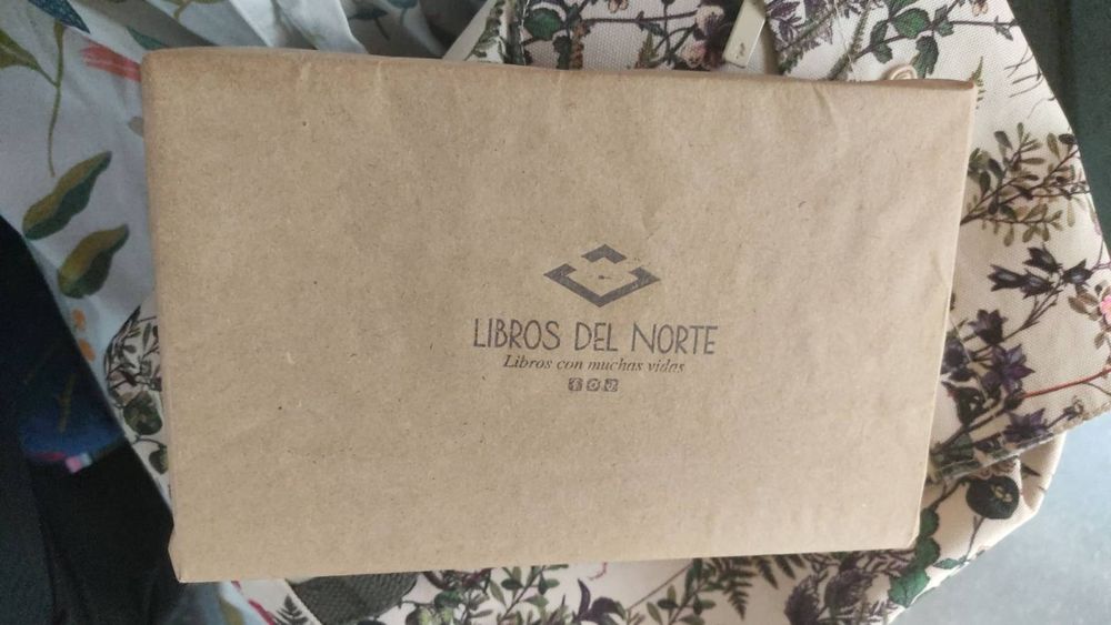Libro envuelto en papel Kraft con el logo estampado de Libros del Norte