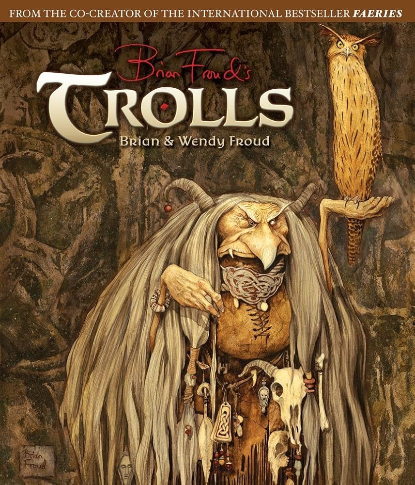 The cover of Brian and Wendy Froud's art book "Trolls", featuring one of Brian Froud's illustrations from the book: a troll crone, wizened and gnarled, glares over her beaky nose with her remaining eye. Leatherwork and beads, skulls and stone talismans adorn her stout woolen dress, and curtains of grey hair like silvered moss drape her bent frame. Perched on her uplifted, seemingly frail hand, a long-eared owl, tawny and tall, stares with golden eyes unblinking. Dank wood and fen surround the troll witch and her familiar: lichen and shadows cling wetly to graven stones and twisted trees.