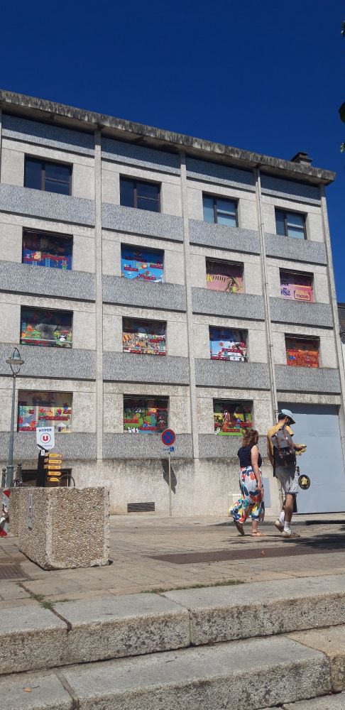 Façade d'immeuble dont les fenêtres sont barrées de panneaux thème jeux / jeux vidéos 