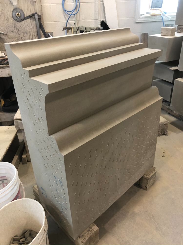 portion of cornice of a classical building, including larmier and cymatium, in the process of being cut from Wallace sandstone; standing upright though it's orientation in the building would be horizontal