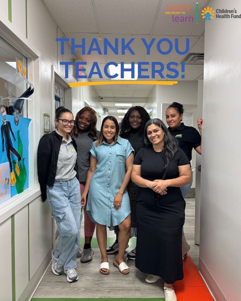 Group of five educators smiling in a school corridor under a 'THANK YOU TEACHERS!' banner, with logos for 'Healthy and Ready to Learn' and 'Children's Health Fund' visible.