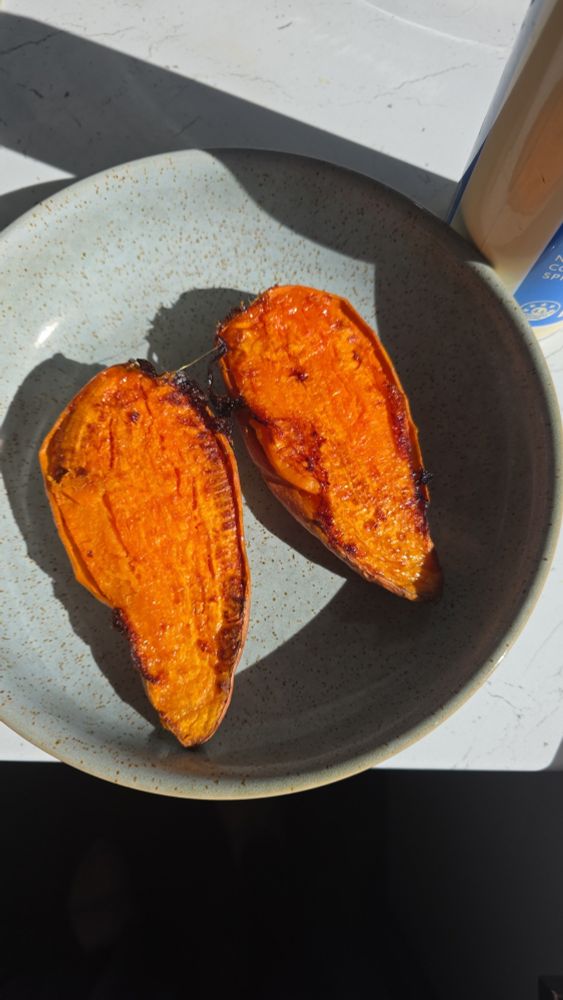 a sweet potato cut in half (long ways); roasted. in a light green bowl