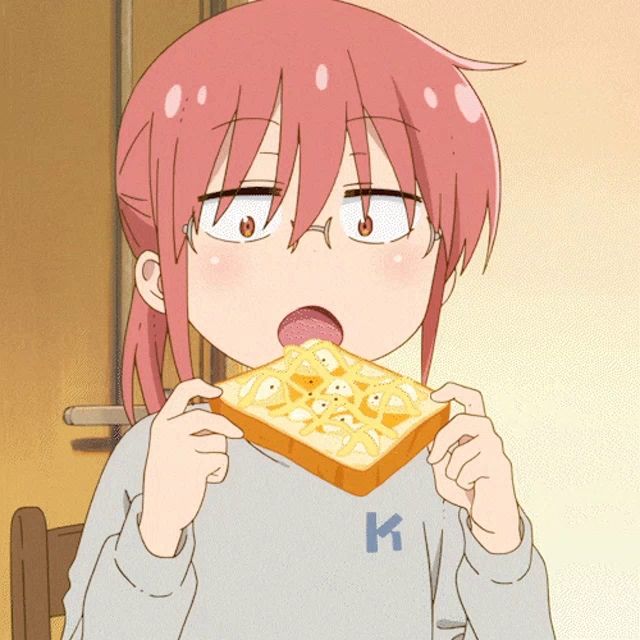 a girl with pink hair and glasses is eating a piece of toast with the letter k on her shirt