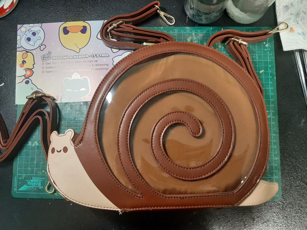 An ita-bag shaped like a snail. The shell is the window