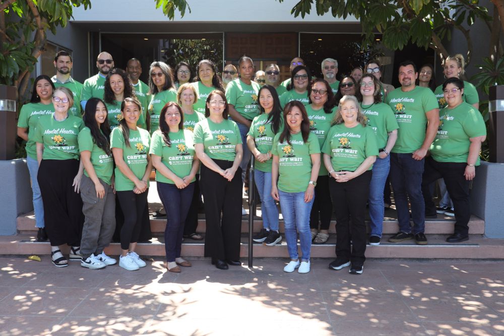33 district employees wearing matching green tee shirts for Mental Health Awareness Month