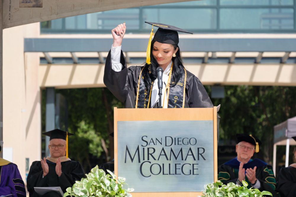 The student Commencement speaker at the podium at Miramar College's graduation ceremony.