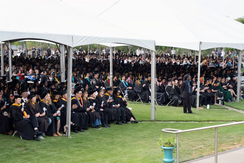 Nearly 400 graduates seated under canopies during their commencement ceremony.