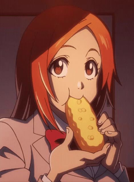 a girl with orange hair is eating a yellow item