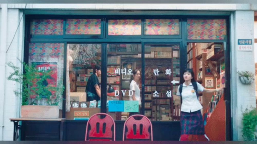 a girl stands in front of a store called dvd